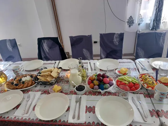 Masă festivă cu ouă vopsite, pâine caldă și lapte proaspăt de casă